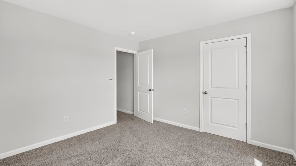 Bedroom with carpet and window.