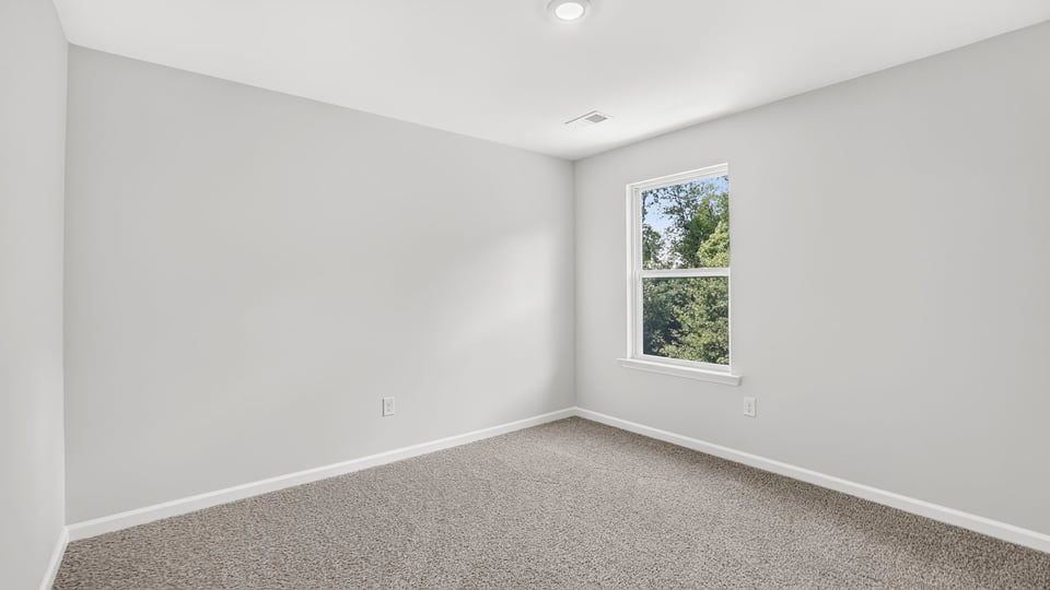 Bedroom with carpet and window.