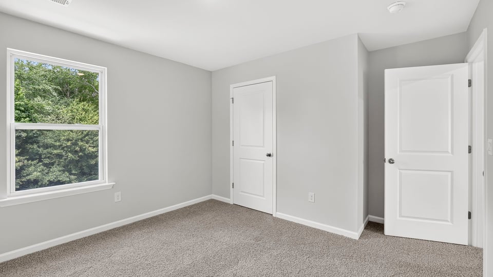 Bedroom with carpet and window.