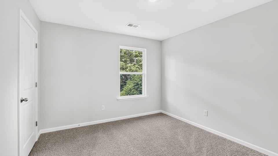Bedroom with carpet and window.