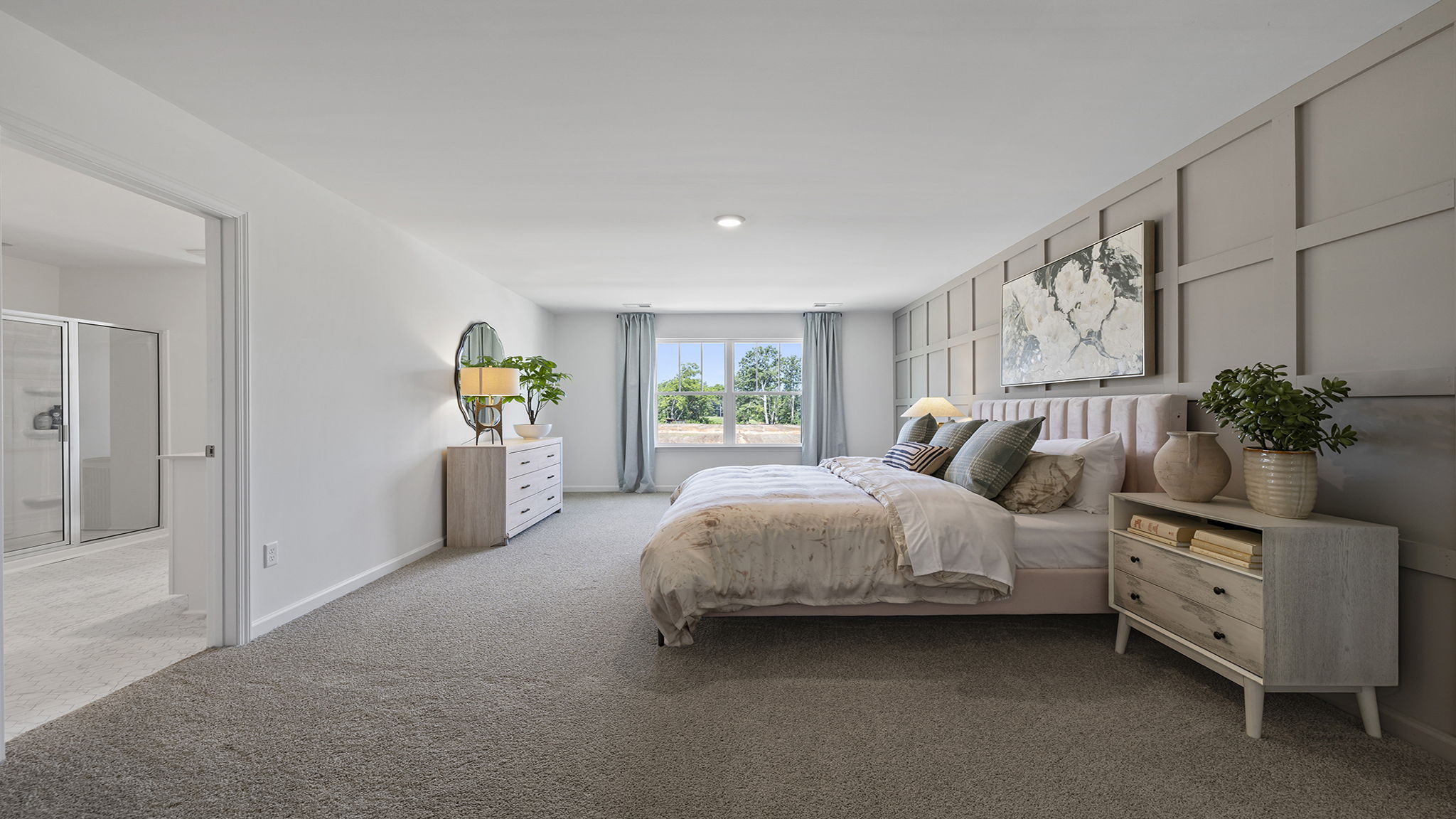Primary bedroom with carpet and windows.