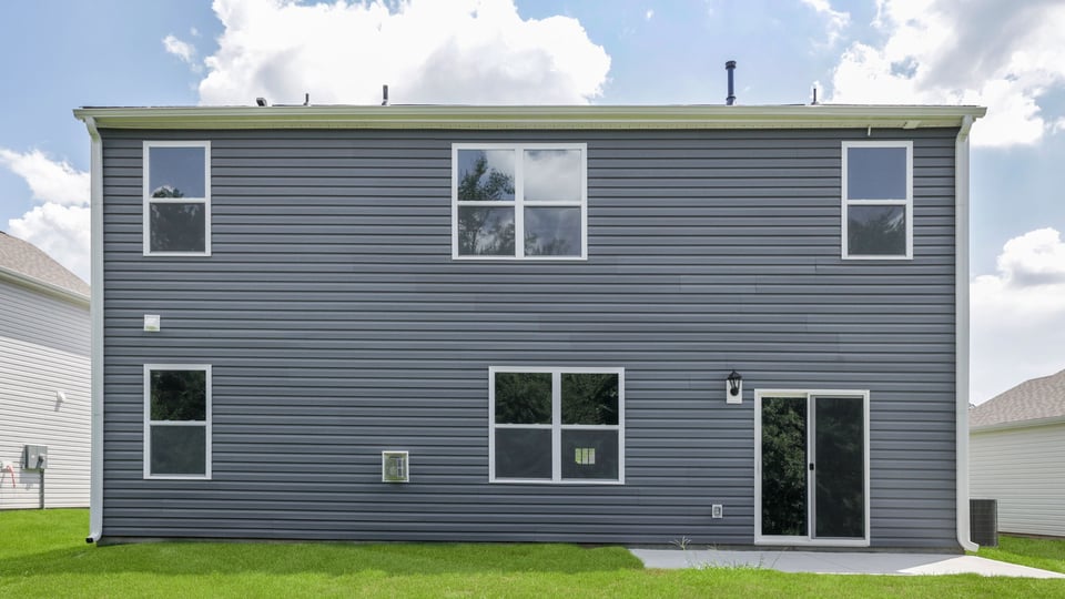 Back exterior of home with large backyard.