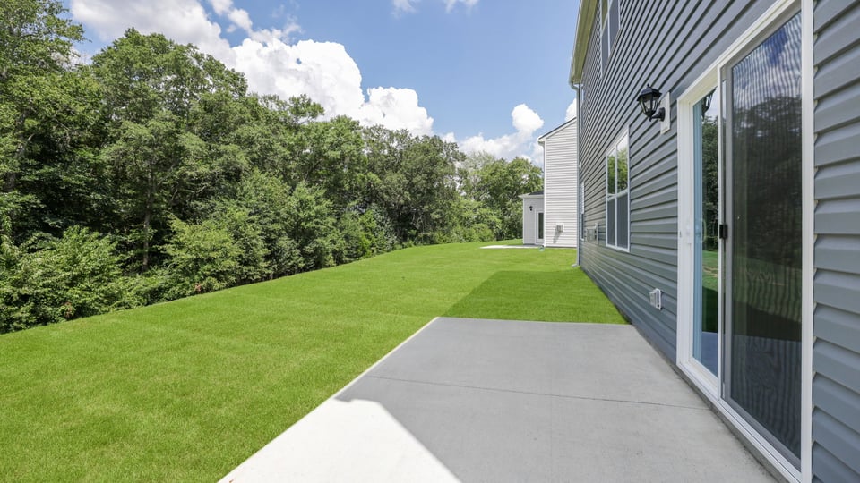 Back exterior of home with patio.