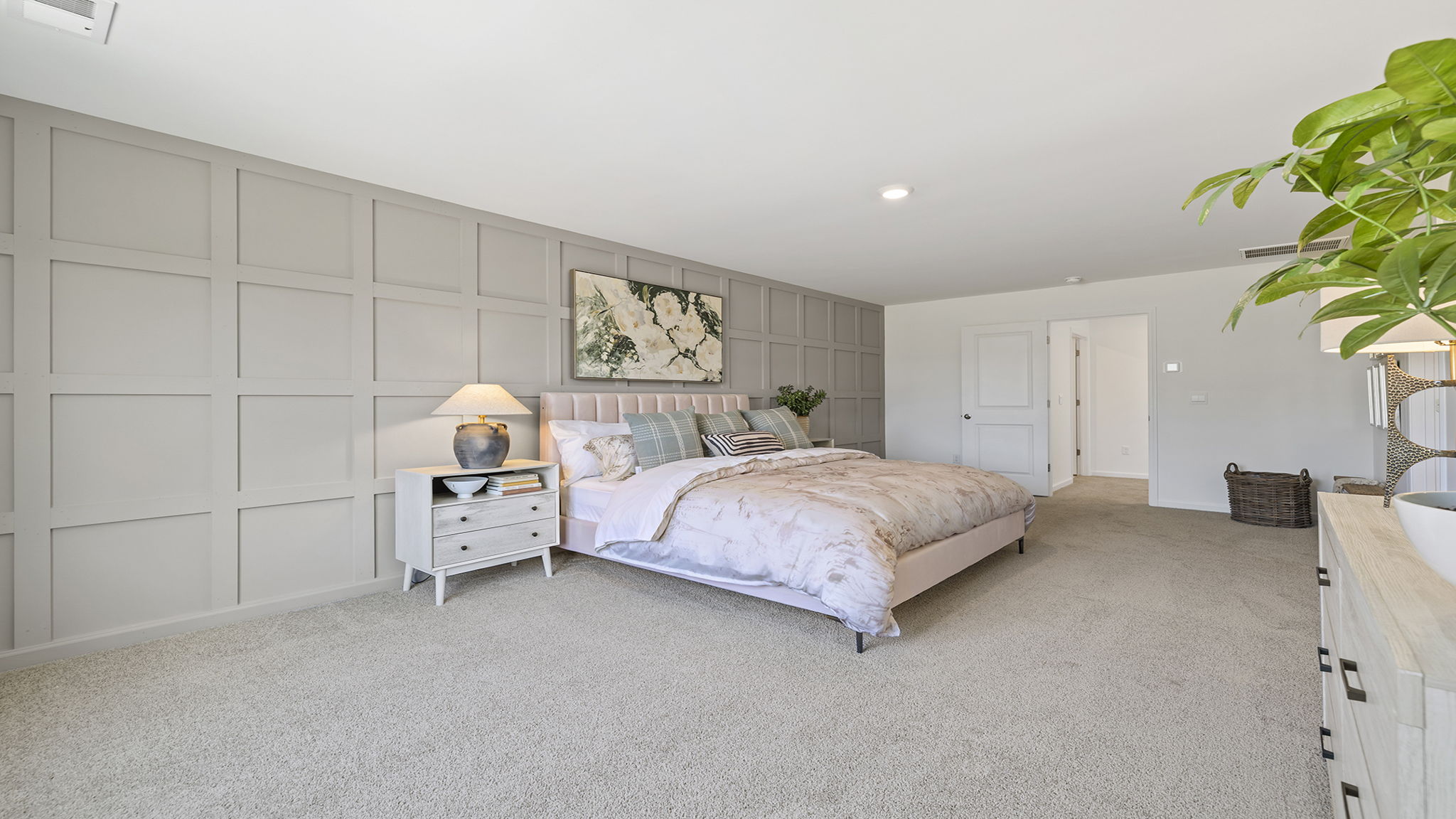 Primary bedroom with carpet and window.