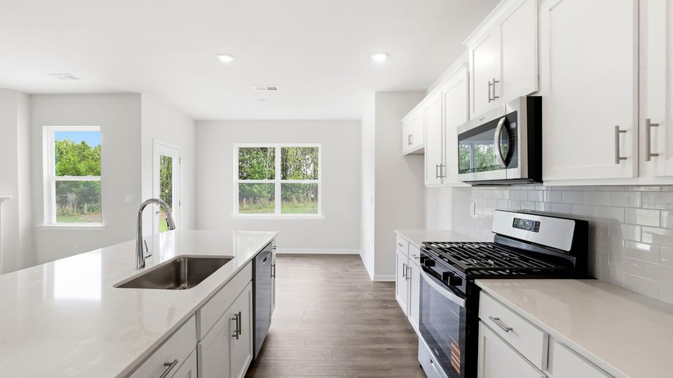 Kitchen and island with stainless steel appliances.