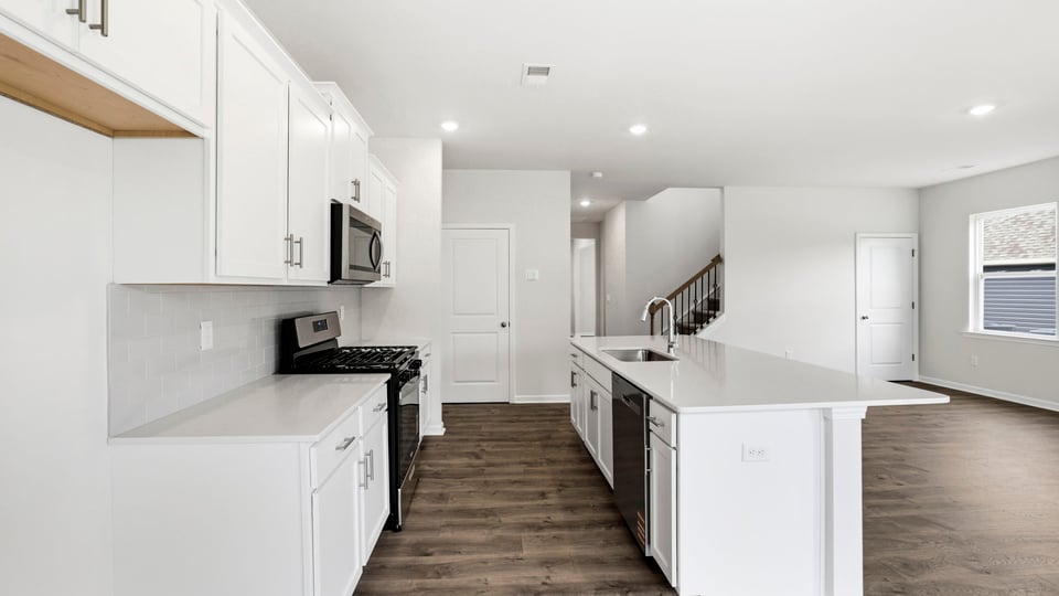 Kitchen and island with stainless steel appliances.