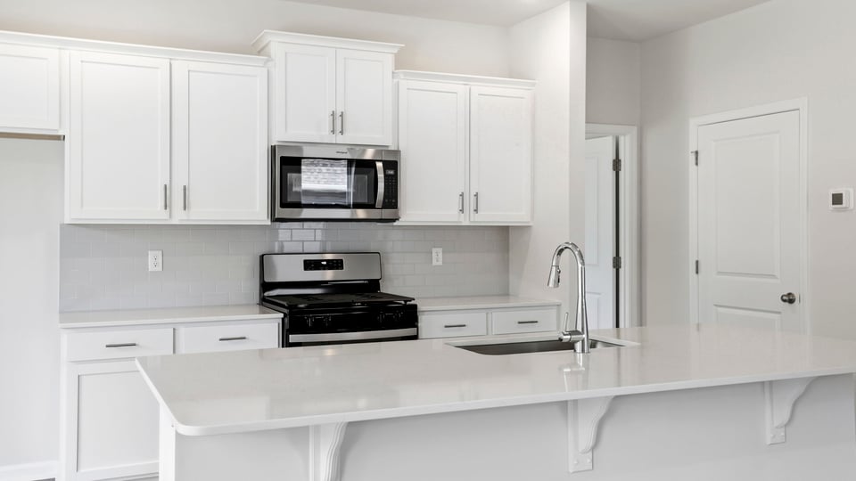 Kitchen and island with stainless steel appliances.