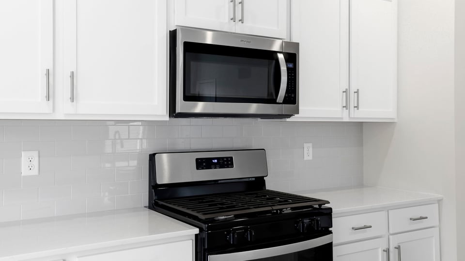 Kitchen and island with stainless steel appliances.