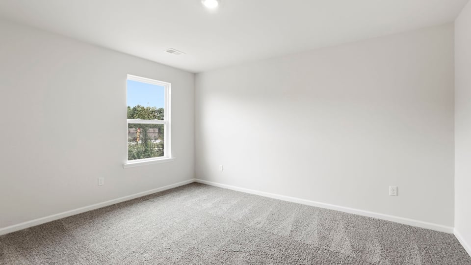 Bedroom with carpet and window.