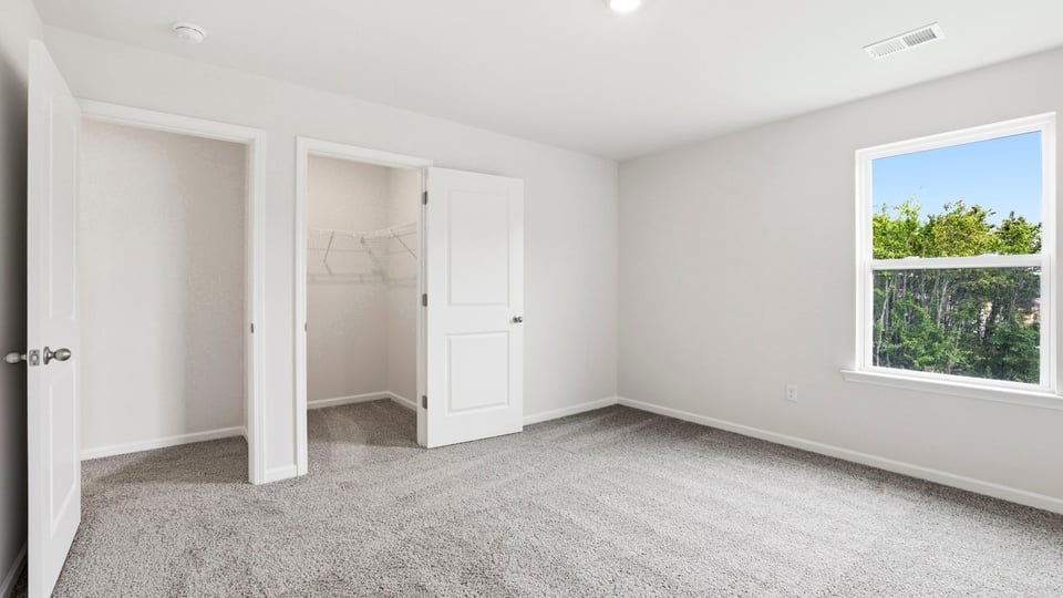 Bedroom with carpet and window.