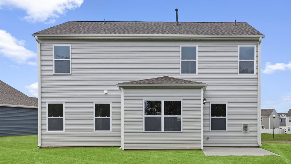 Back exterior of home with large backyard.