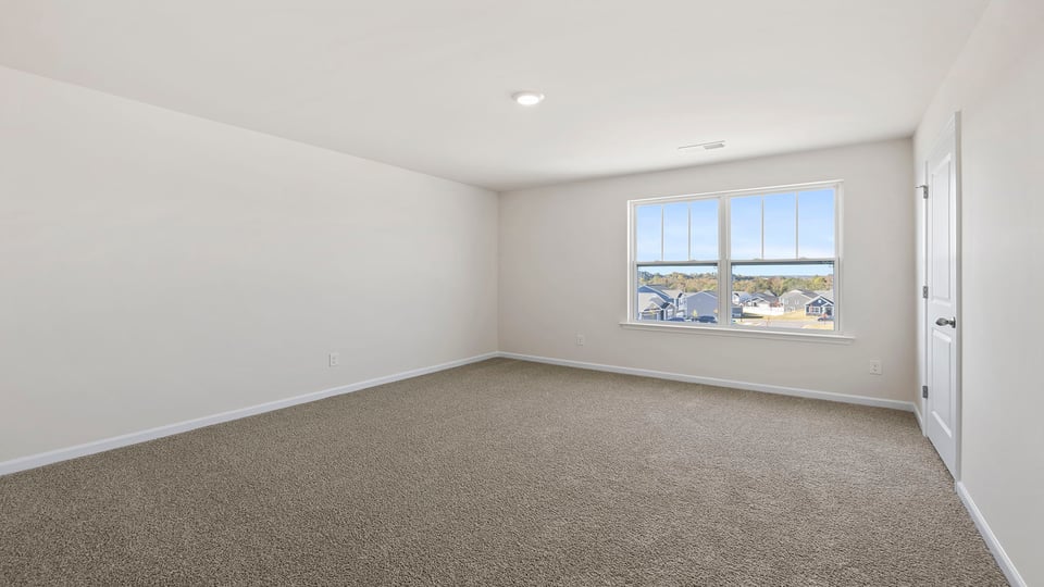 Bedroom with large window and carpet.