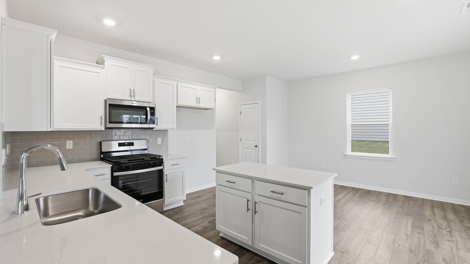 Open kitchen with island and recessed lighting.