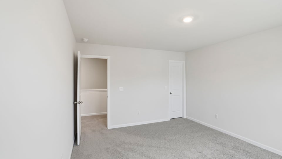 Bedroom with large window and carpet.