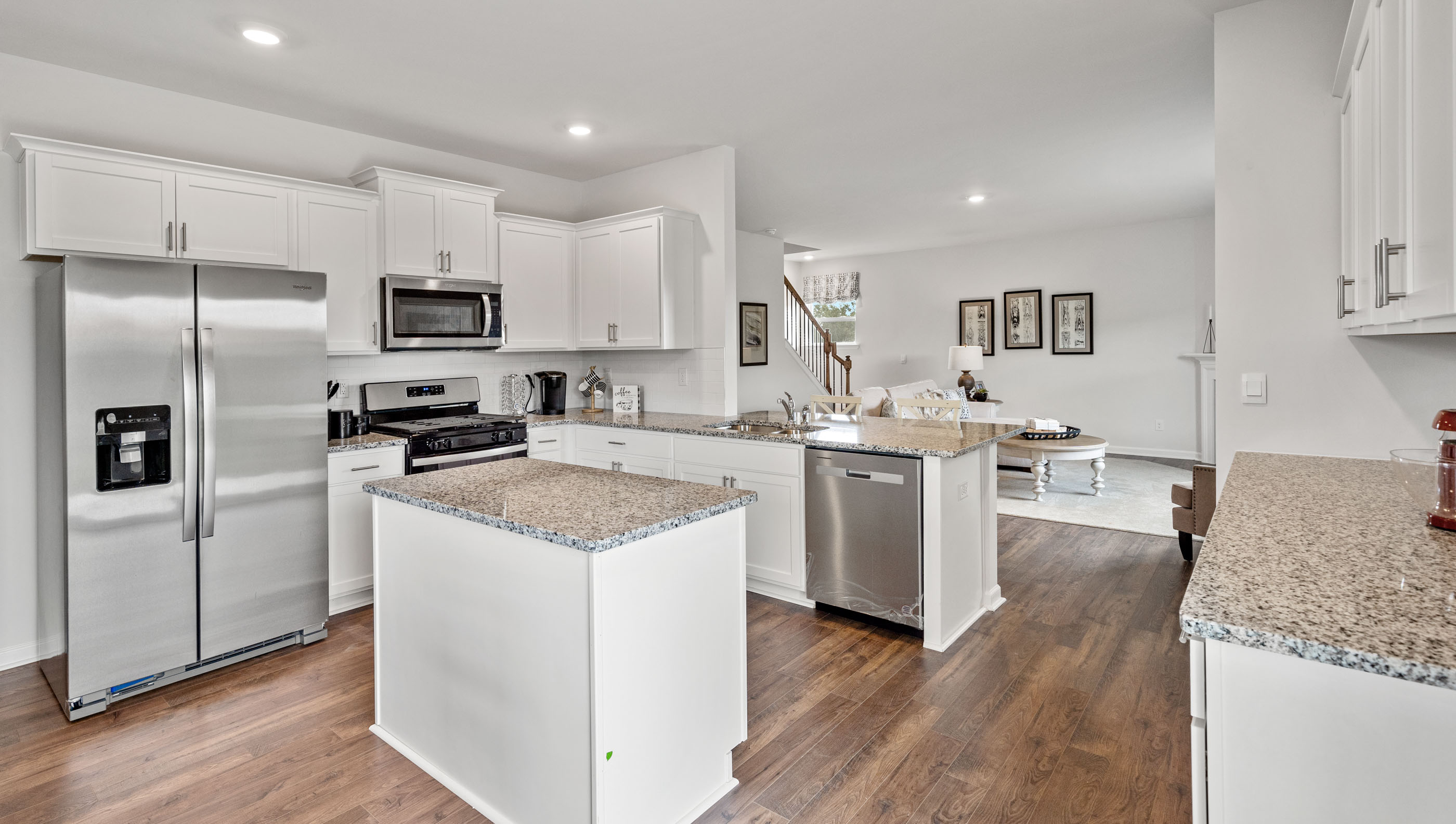 Kitchen and island with granite counter tops and stainless steel appliances.