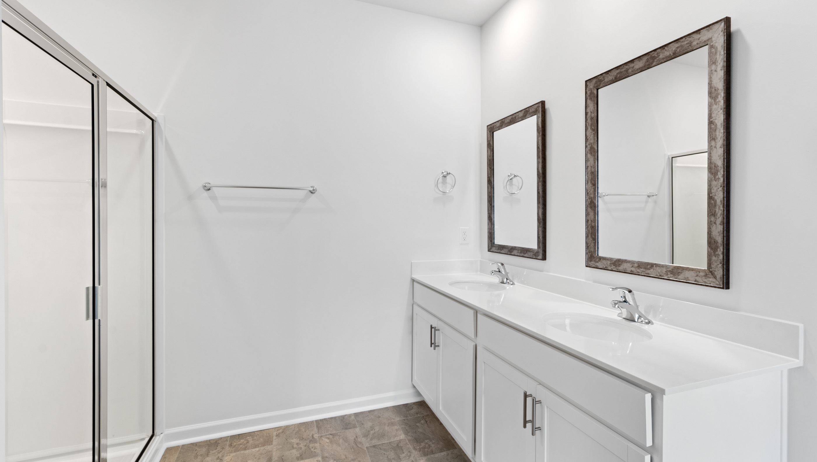 Bathroom with double vanity sink and shower.