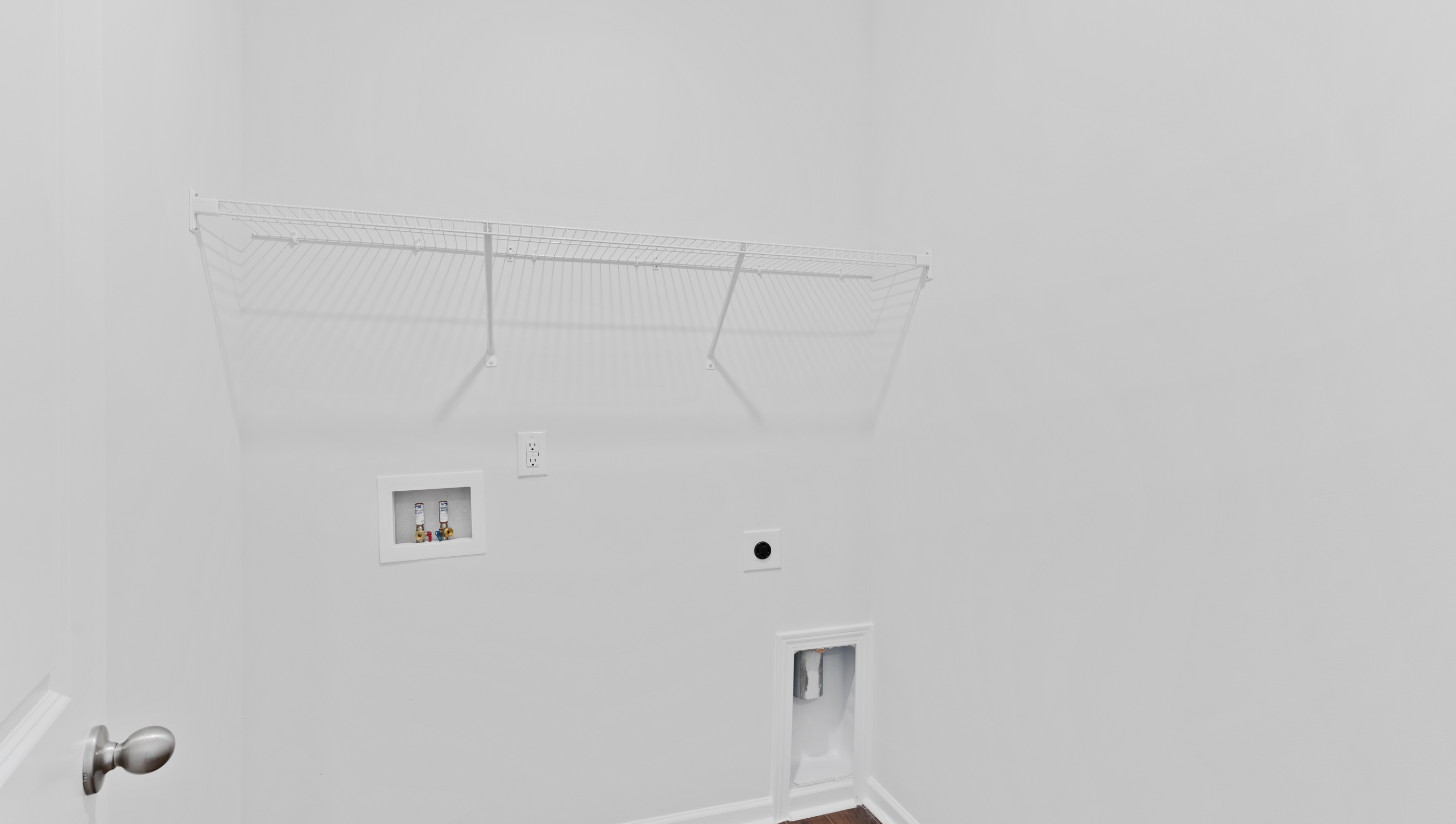 Laundry room with hanging storage racks.