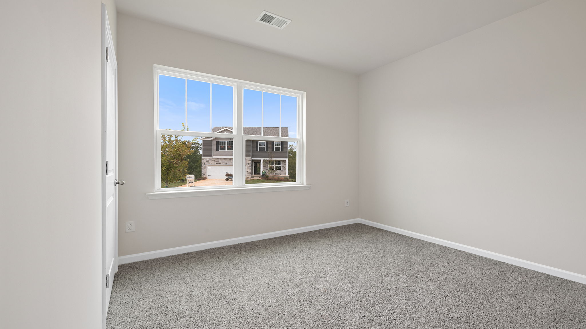 Front bedroom with large window and carpet.