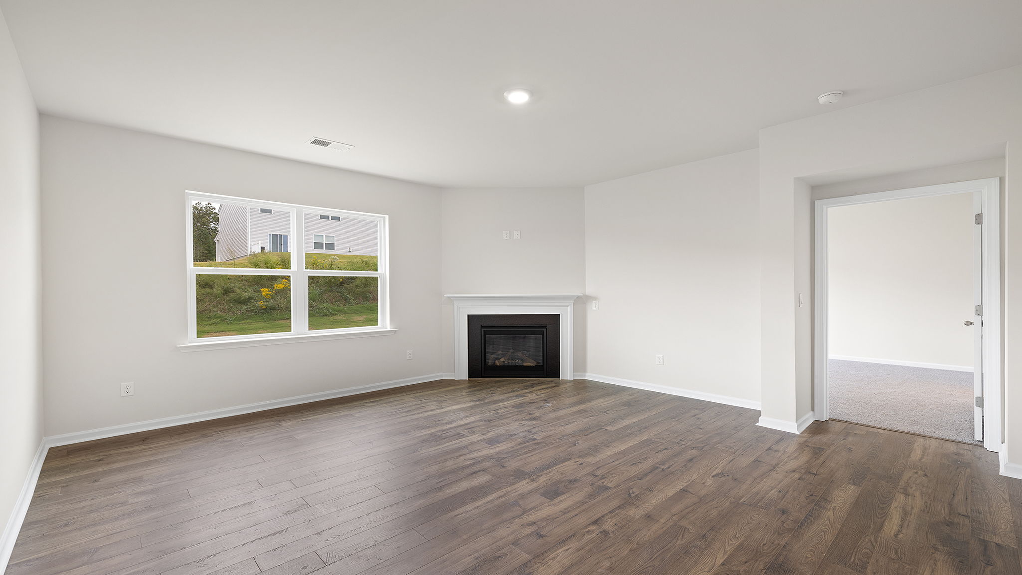 Family room with gas log fireplace and large windows.