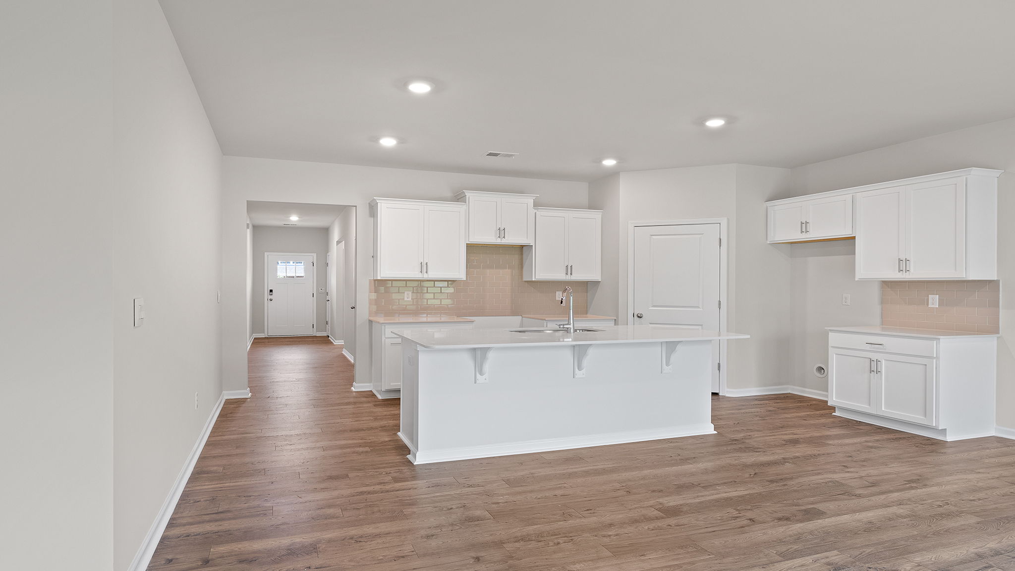 View of open kitchen and hallway to the entrance.