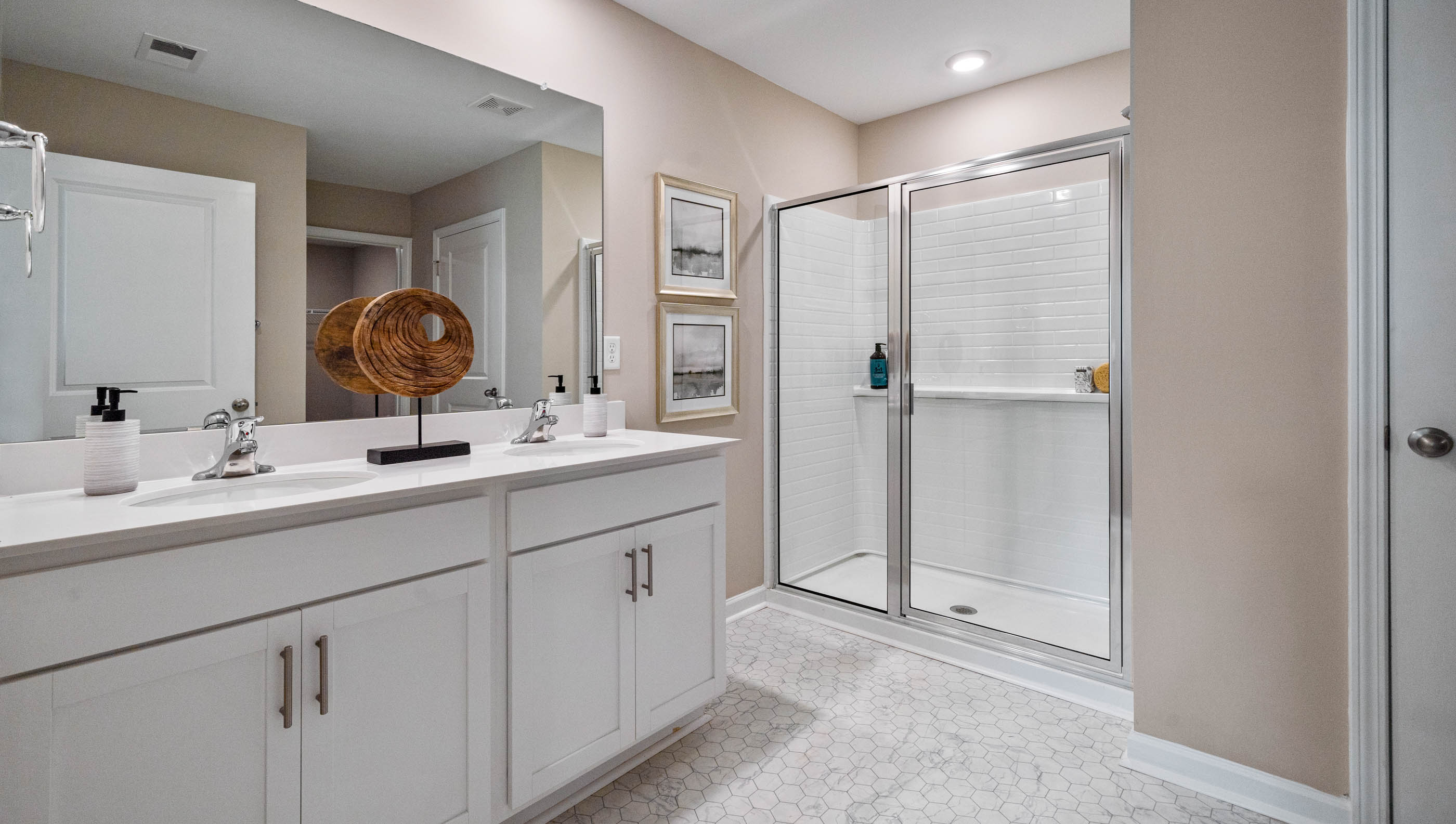 Bathroom with double vanity sink and shower.