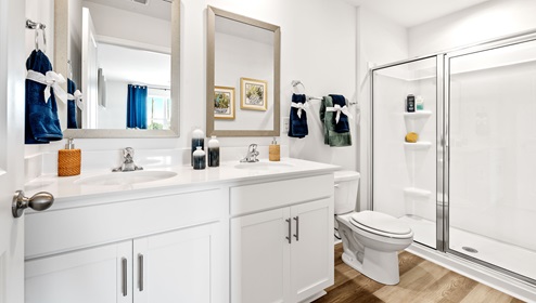 Primary bathroom with walk in shower and dual sink vanity.