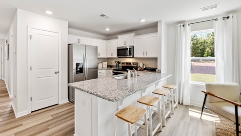Kitchen with half island with granite counter tops.