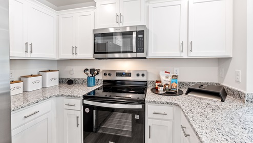 Kitchen with half island with granite counter tops.