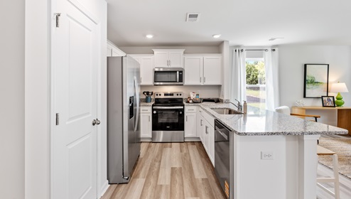 Kitchen with half island with granite counter tops.