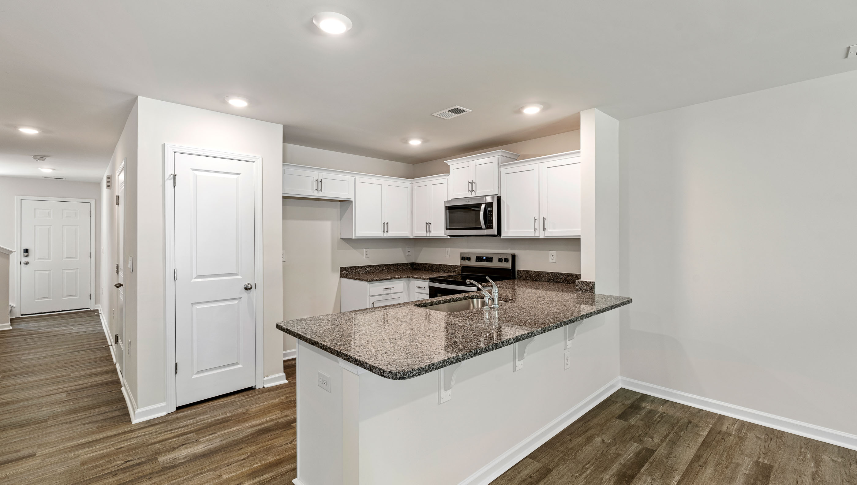 View of kitchen and hallway to the entrance.