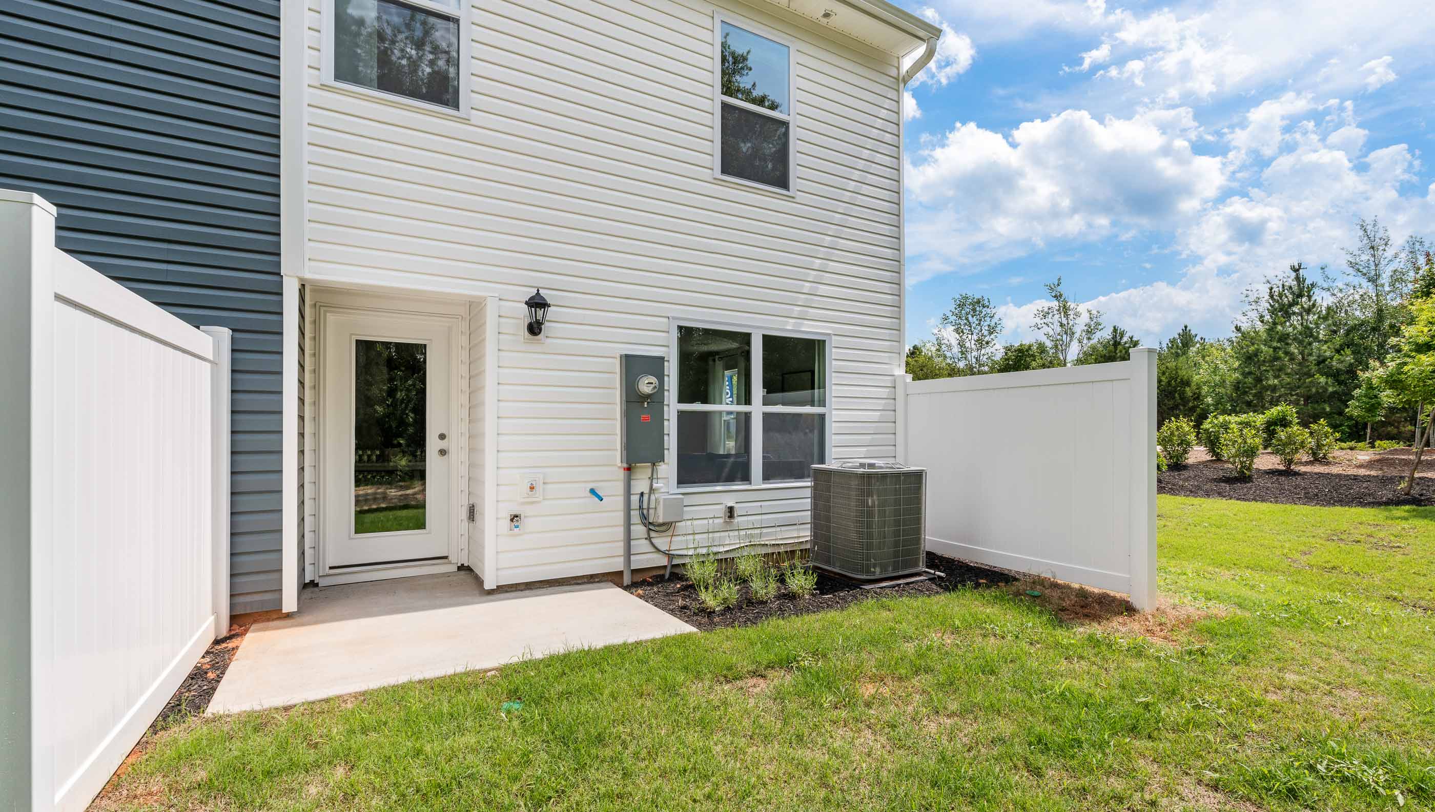 Back exterior with patio and large backyard.