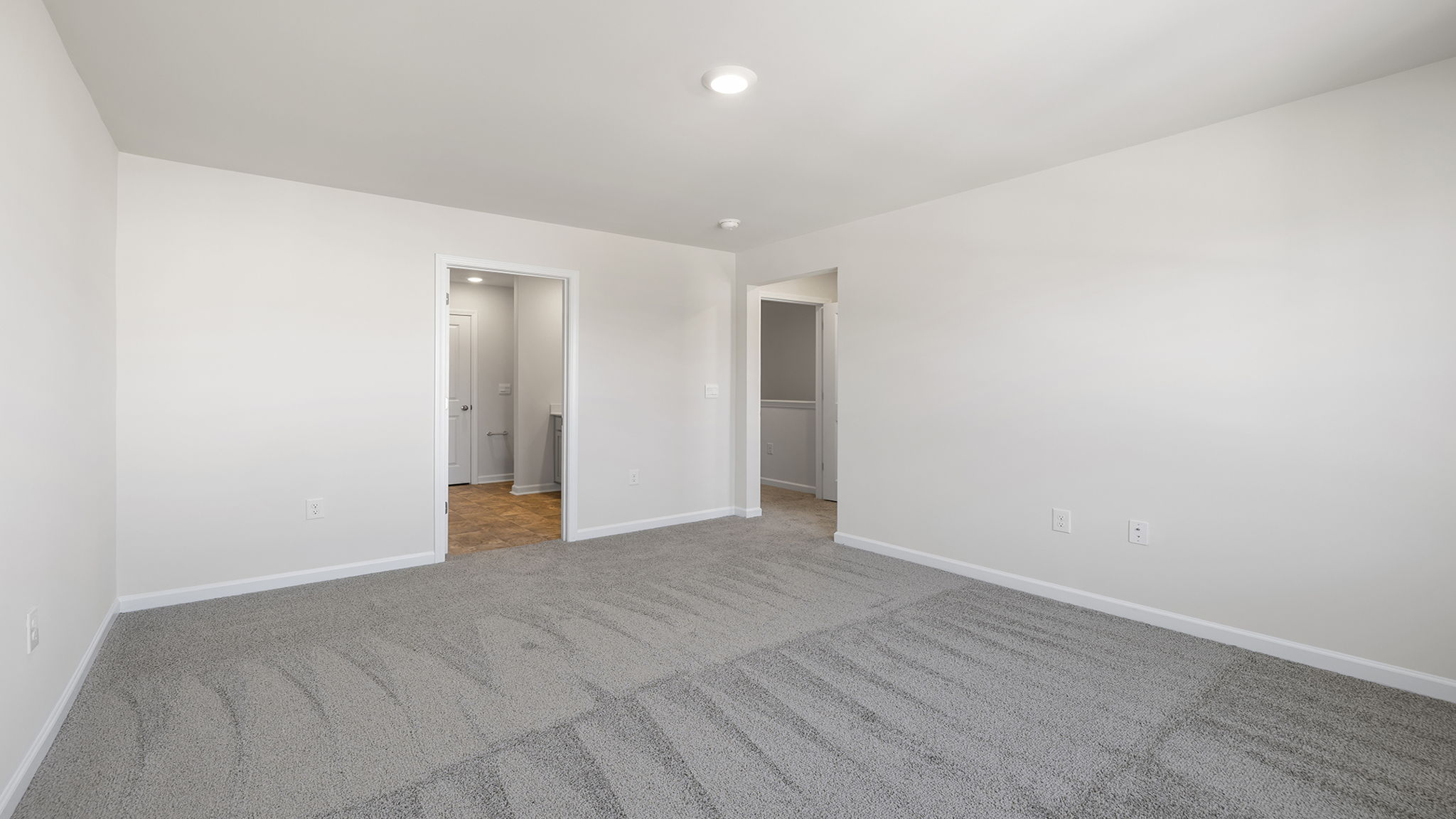 Primary bedroom with window and carpet.