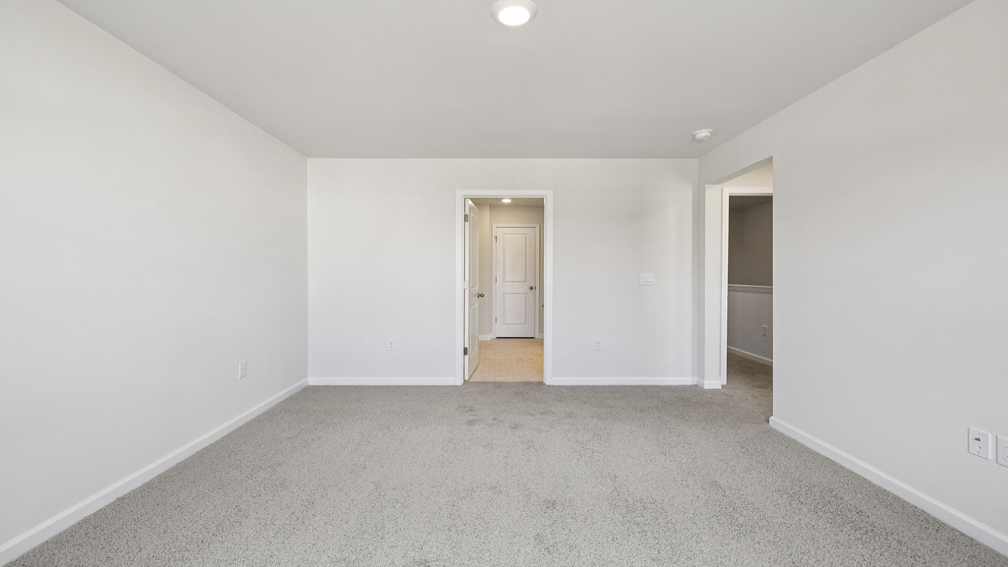 Primary bedroom with window and carpet.