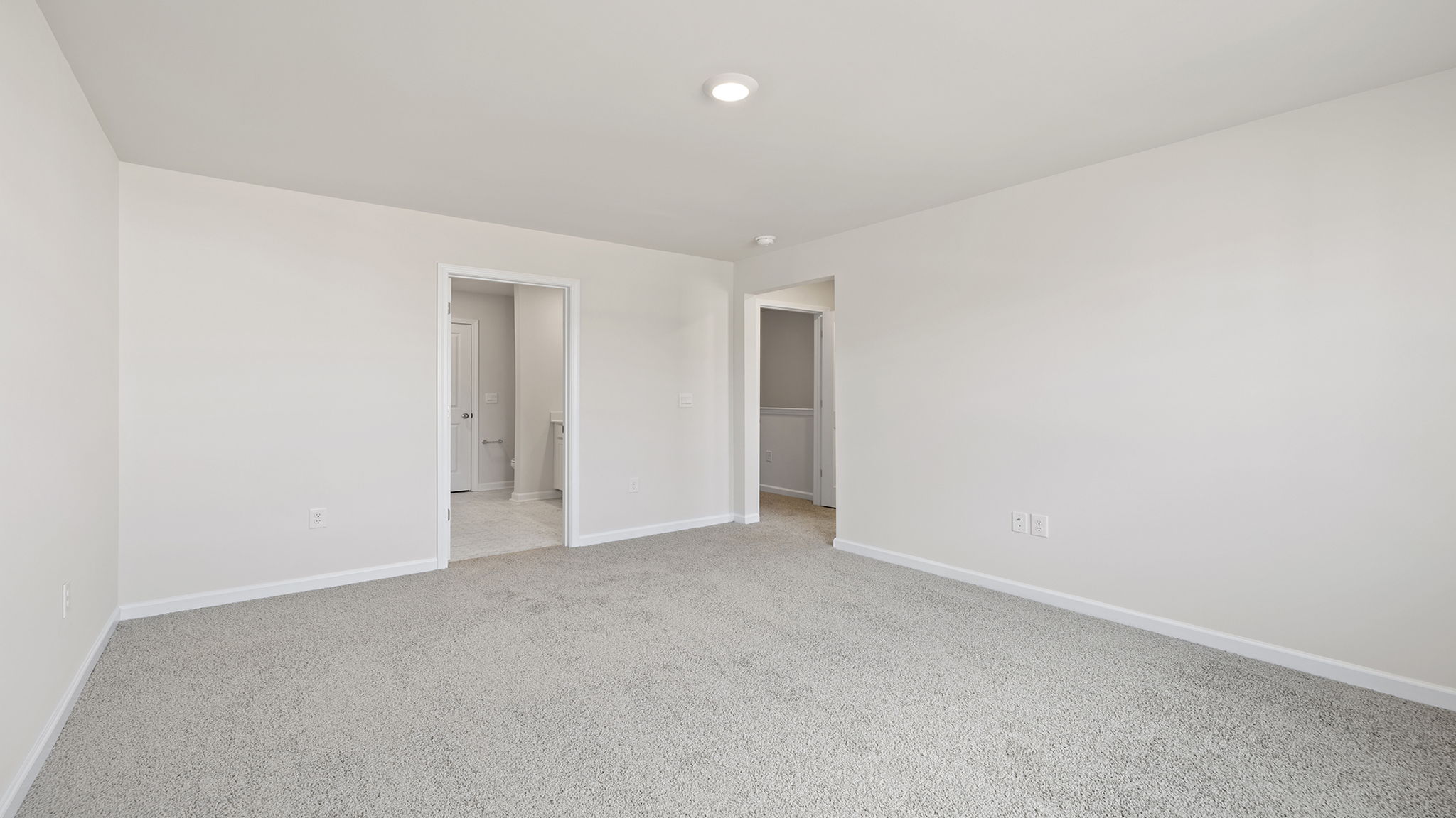 Primary bedroom with window and carpet.