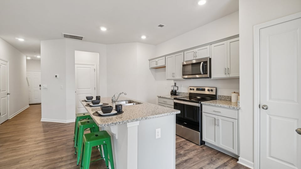 Kitchen and island with stainless steel appliances.