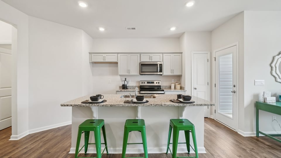 Kitchen and island with stainless steel appliances.
