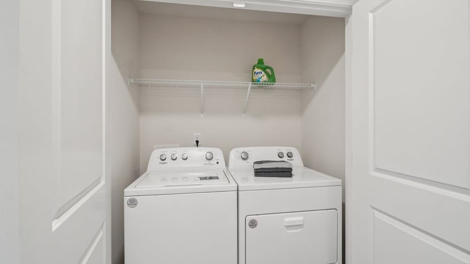 Laundry room with hanging storage racks.