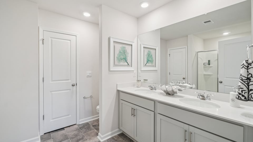 Bathroom with double vanity sink and closet.