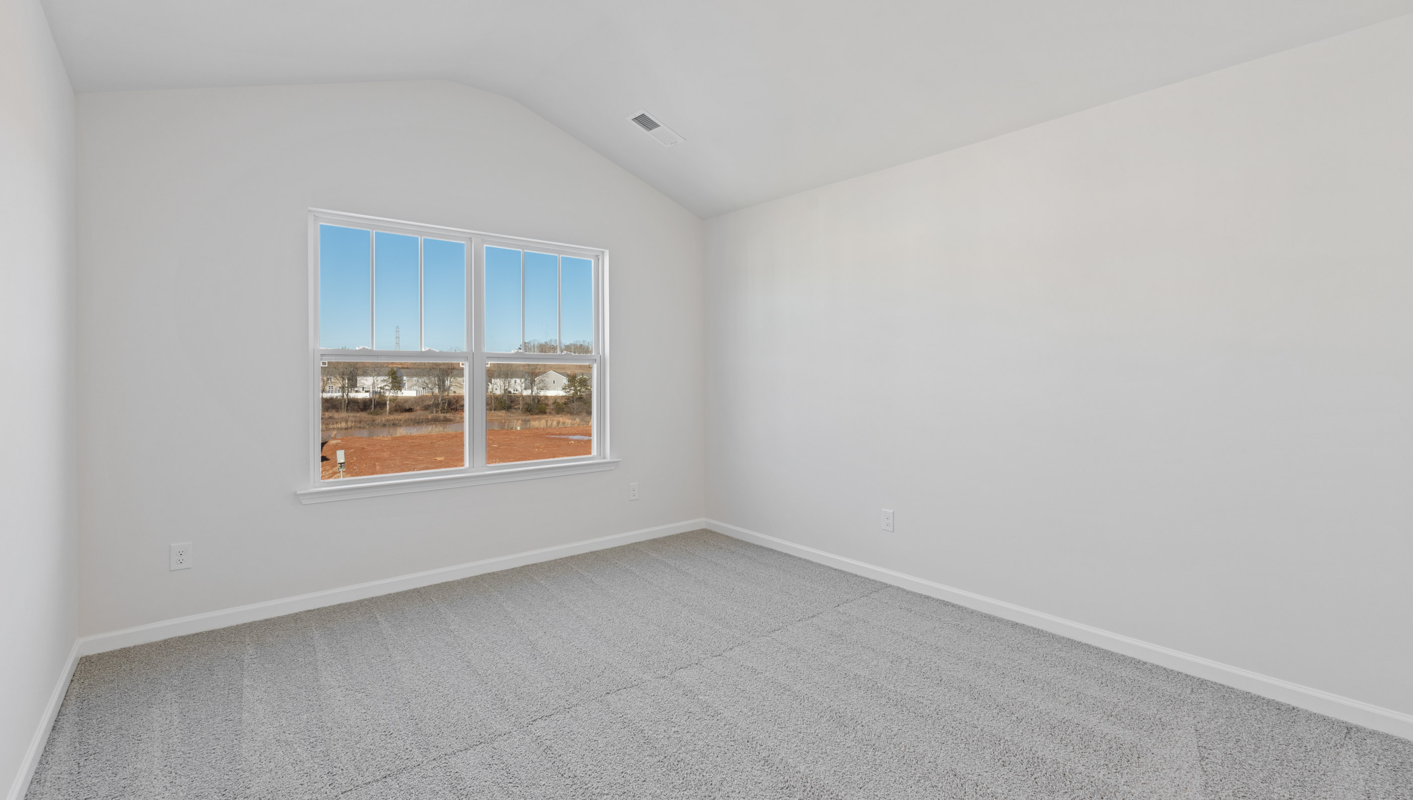 Primary bedroom with window and carpet.