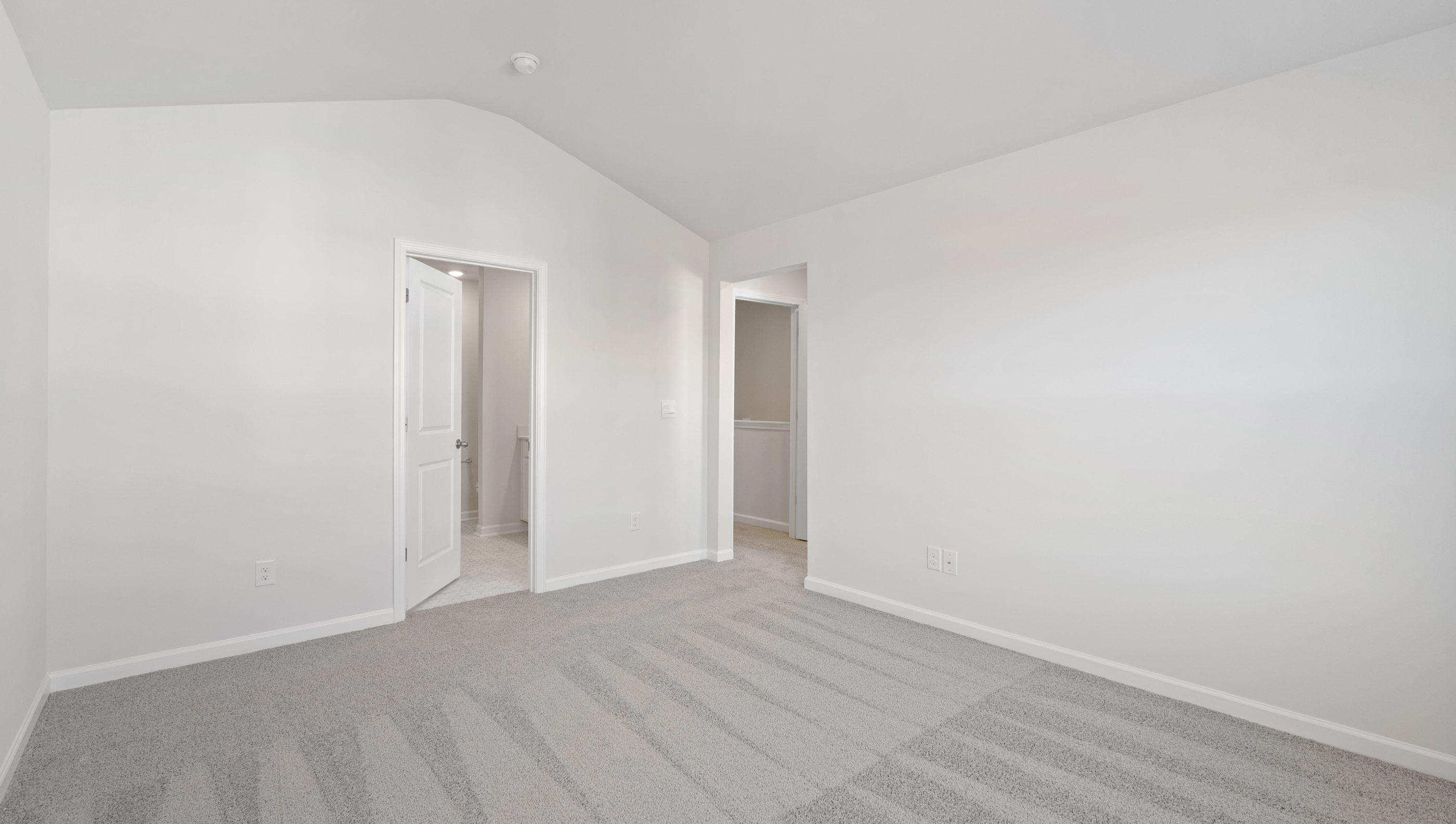Primary bedroom with window and carpet.