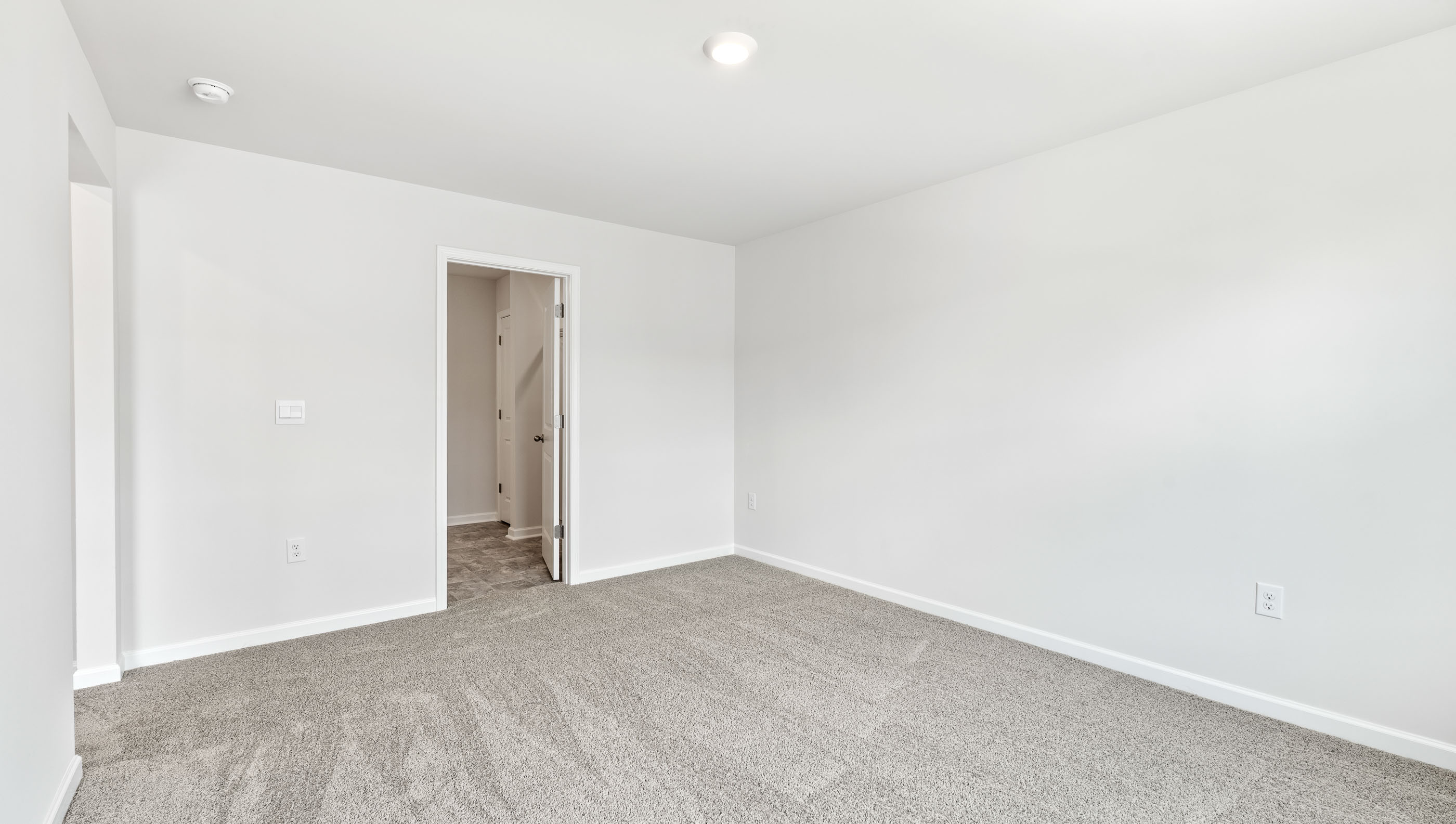 Primary bedroom with window and carpet.
