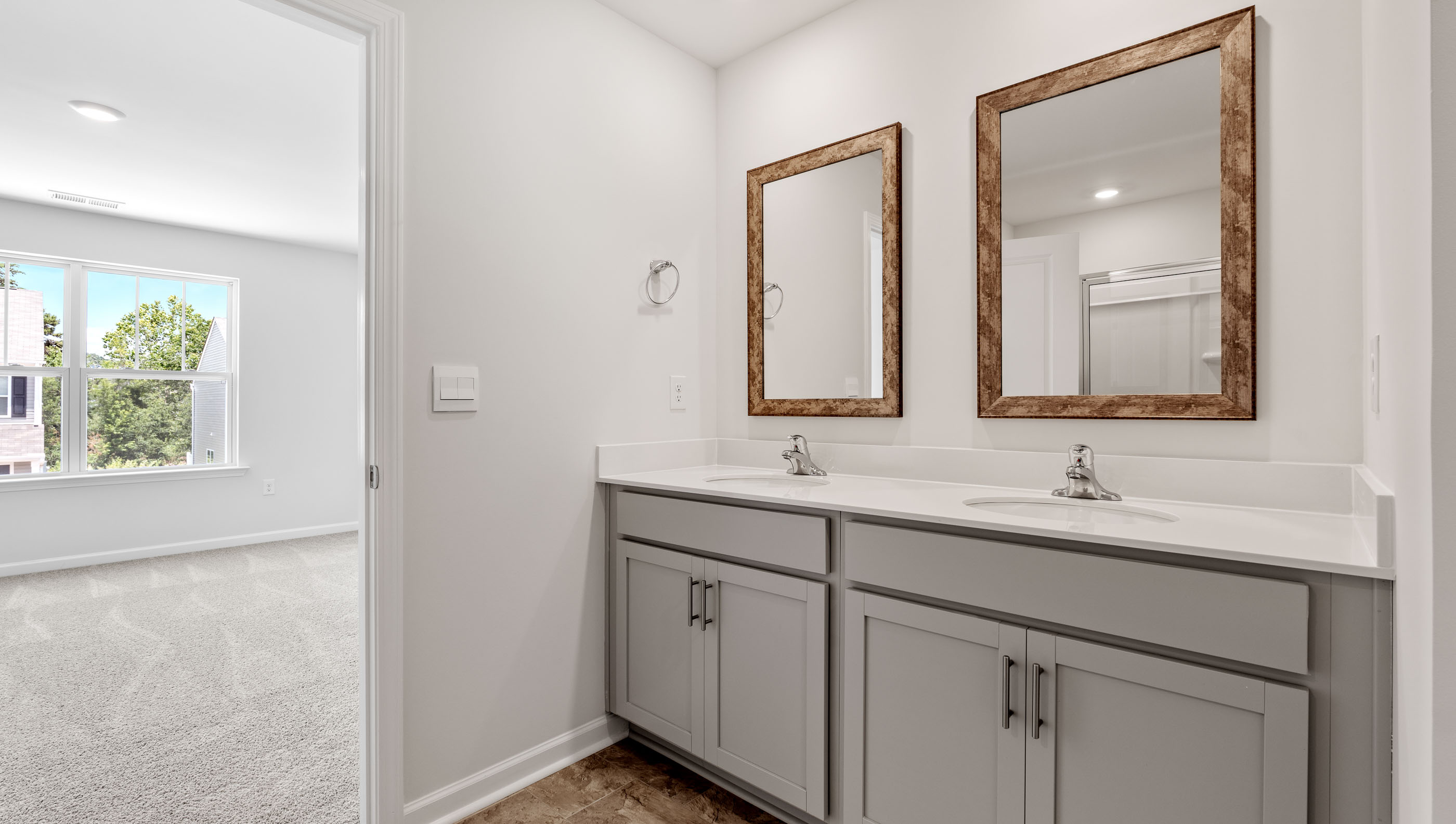 Primary bathroom with dual sink vanity and mirrors.