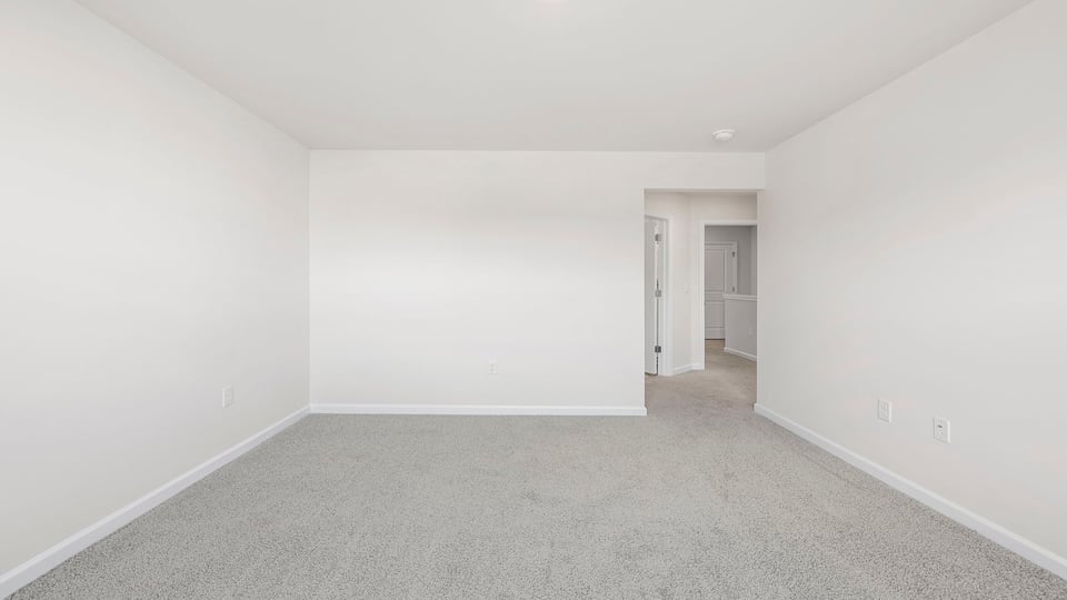 Primary bedroom with window and carpet.