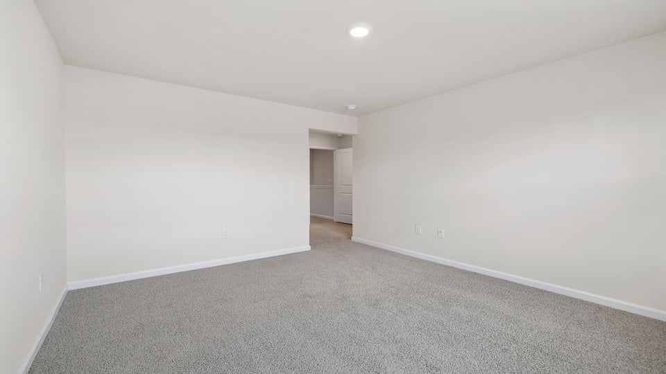 Primary bedroom with window and carpet.