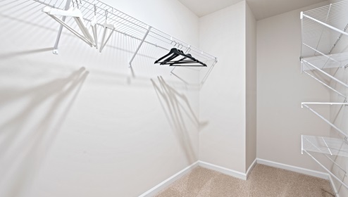 Primary closet with hanging shelves.