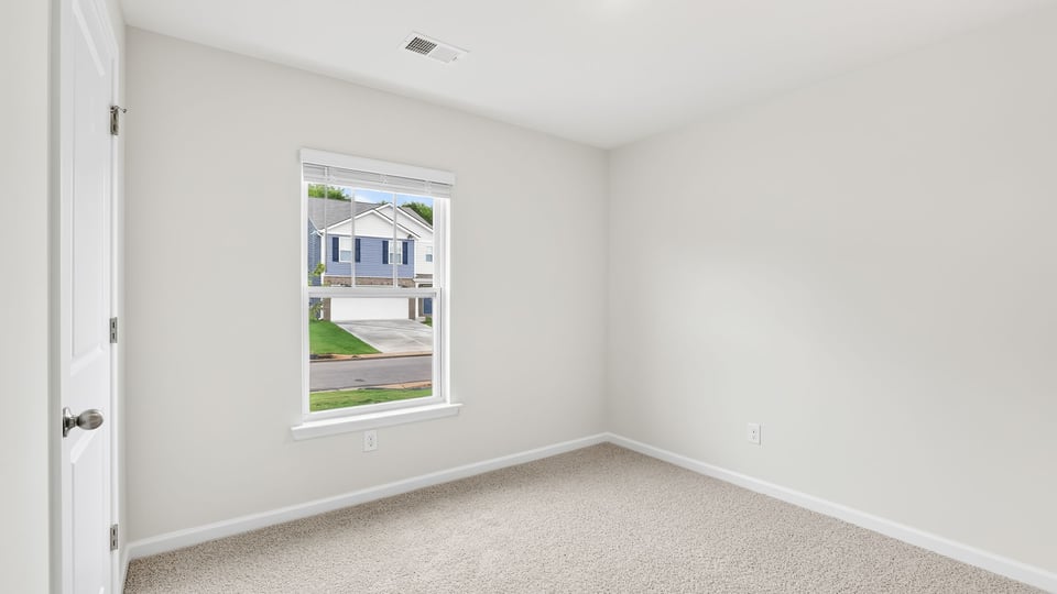 Bedroom with carpet and windows.