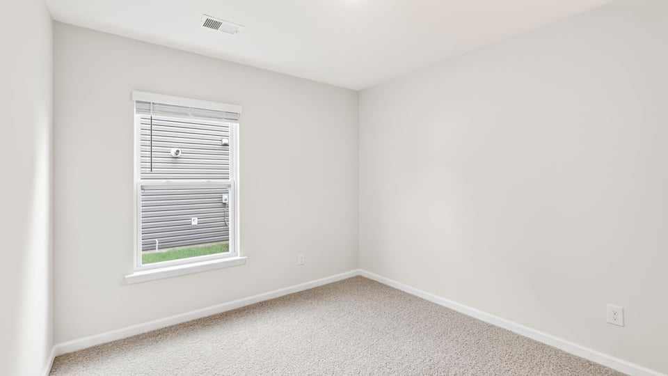 Bedroom with carpet and windows.