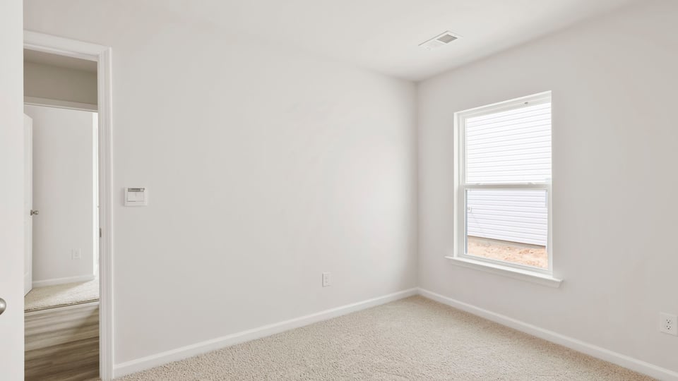 Bedroom with carpet and window.