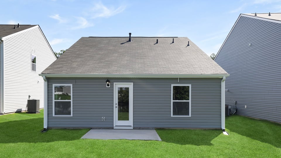 Back exterior of home with large backyard.