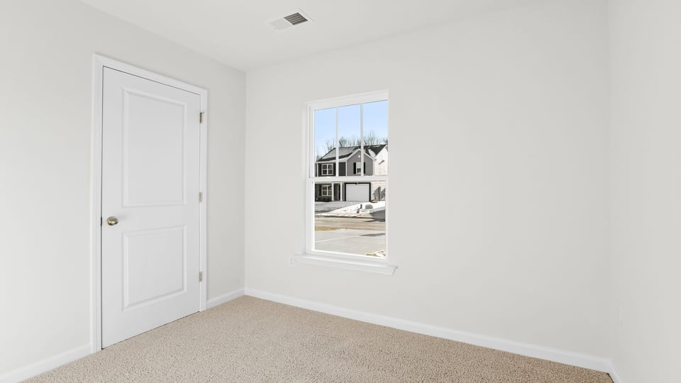 Bedroom with carpet and windows.
